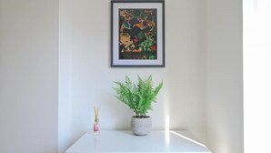 A white desk with a framed picture and a potted plant. - Monopoly Breeze House (Brighton and Hove)