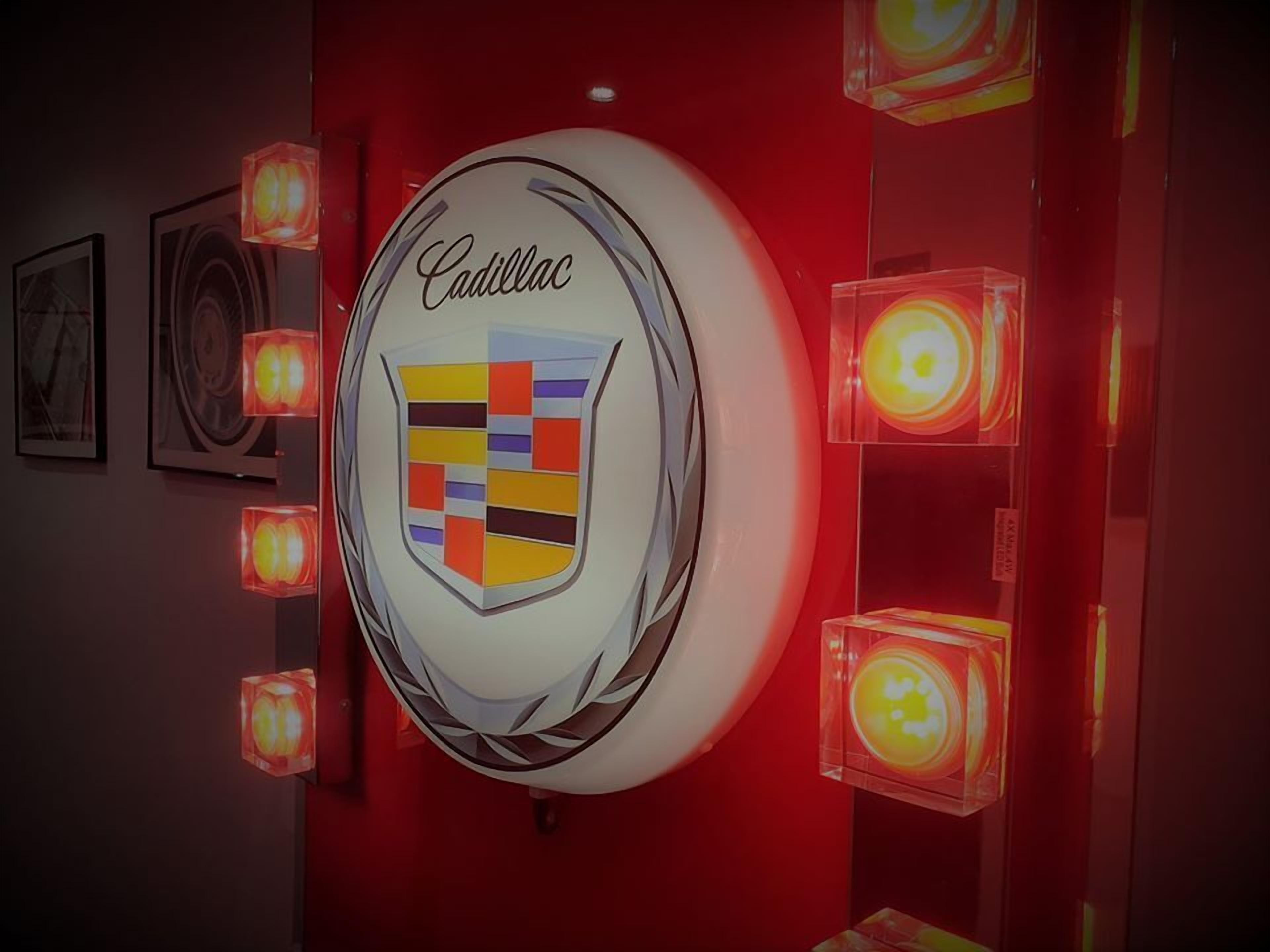 A wall-mounted Cadillac emblem with a shield logo, surrounded by illuminated cube-shaped lights.