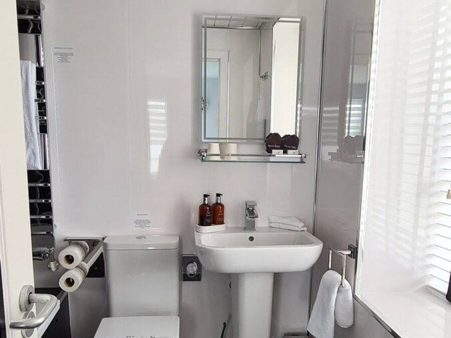 Un baño moderno con inodoro, lavabo y zona de ducha.