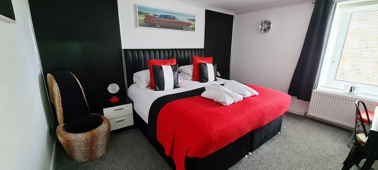 Une chambre à coucher avec un lit, une table de chevet, une chaise, un radiateur et une fenêtre.