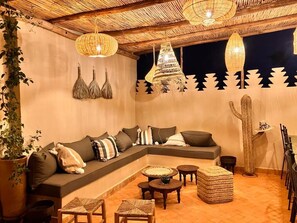 Relax in this stylish living area with a comfortable sofa, coffee table, and woven stools.