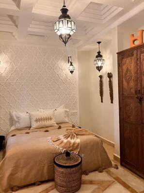 Cozy retreat with a large bed, decorative ceiling, and wall-mounted lights.