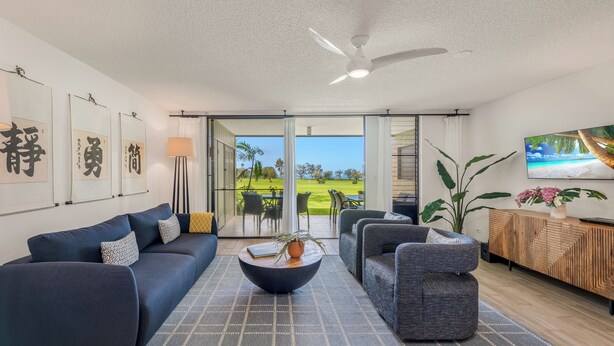 A modern living room with a sofa, armchairs, a coffee table, and a TV.
