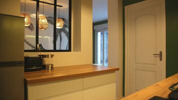 A modern kitchen with a wooden countertop, a built-in stove, and pendant lights.
