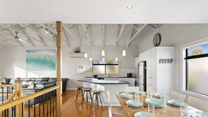 A modern kitchen with a central island, white cabinetry, pendant lighting, and a large window. - Sea La Vie, King Bed, Sleeps 7 (Cowes)