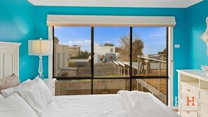 A bedroom with a large window, a ceiling fan, and a view of the backyard. - Sea La Vie, King Bed, Sleeps 7 (Cowes)