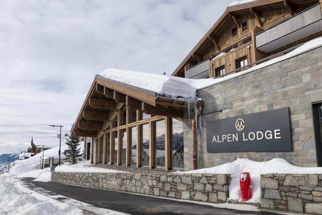 A stone building with a sign reading "ALPEN LODGE".