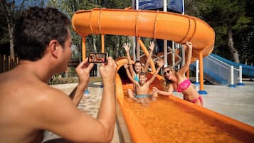 Tobogan d'aigua a un parc aquàtic, amb una persona fent una foto.