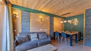 Un salon confortable avec un canapé, une table basse et un coin repas comprenant des chaises et une table.