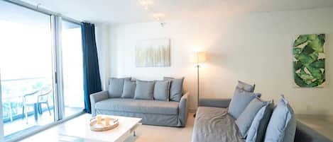 Ein modernes Wohnzimmer mit zwei grauen Sofas, einem weißen Couchtisch und einer Stehlampe.