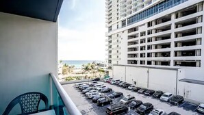 A balcony with a view of a parking lot and a high-rise building with multiple floors and balconies. - SIAN private apartment (Hollywood)