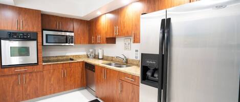A modern kitchen with wooden cabinets, stainless steel appliances, and a built-in oven.
