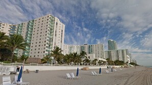 A beachfront hotel with multiple high-rise buildings, palm trees, and beach chairs. - SIAN private apartment (Hollywood)