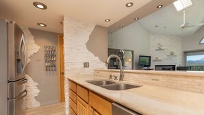 Una cocina moderna con lavavajillas integrado, armarios de madera y una isla grande con fregadero.