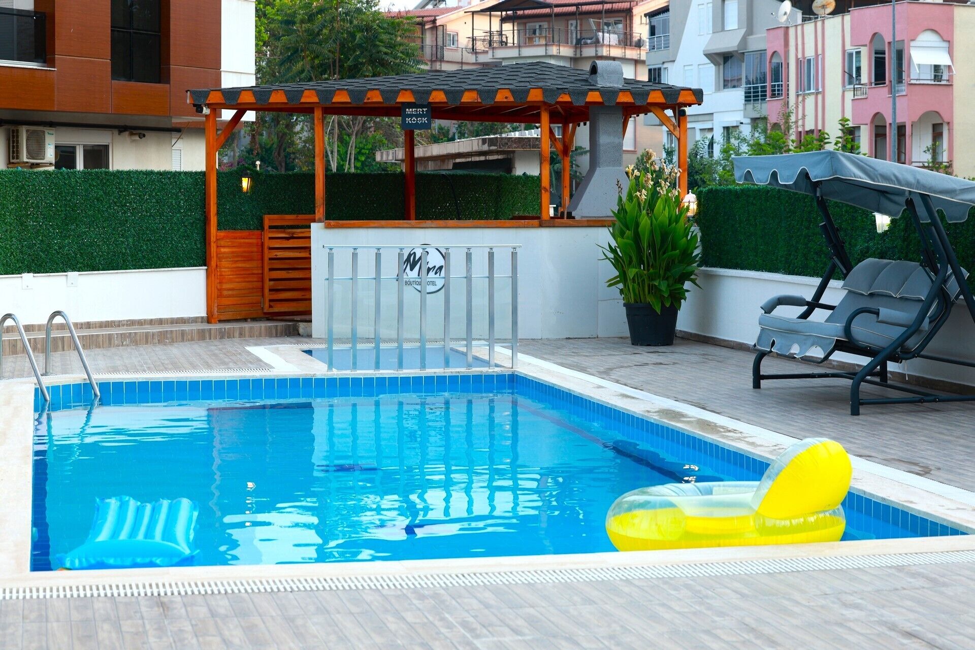 Una piscina con un porche de madera, una silla de descanso y un letrero que indica un sauna.