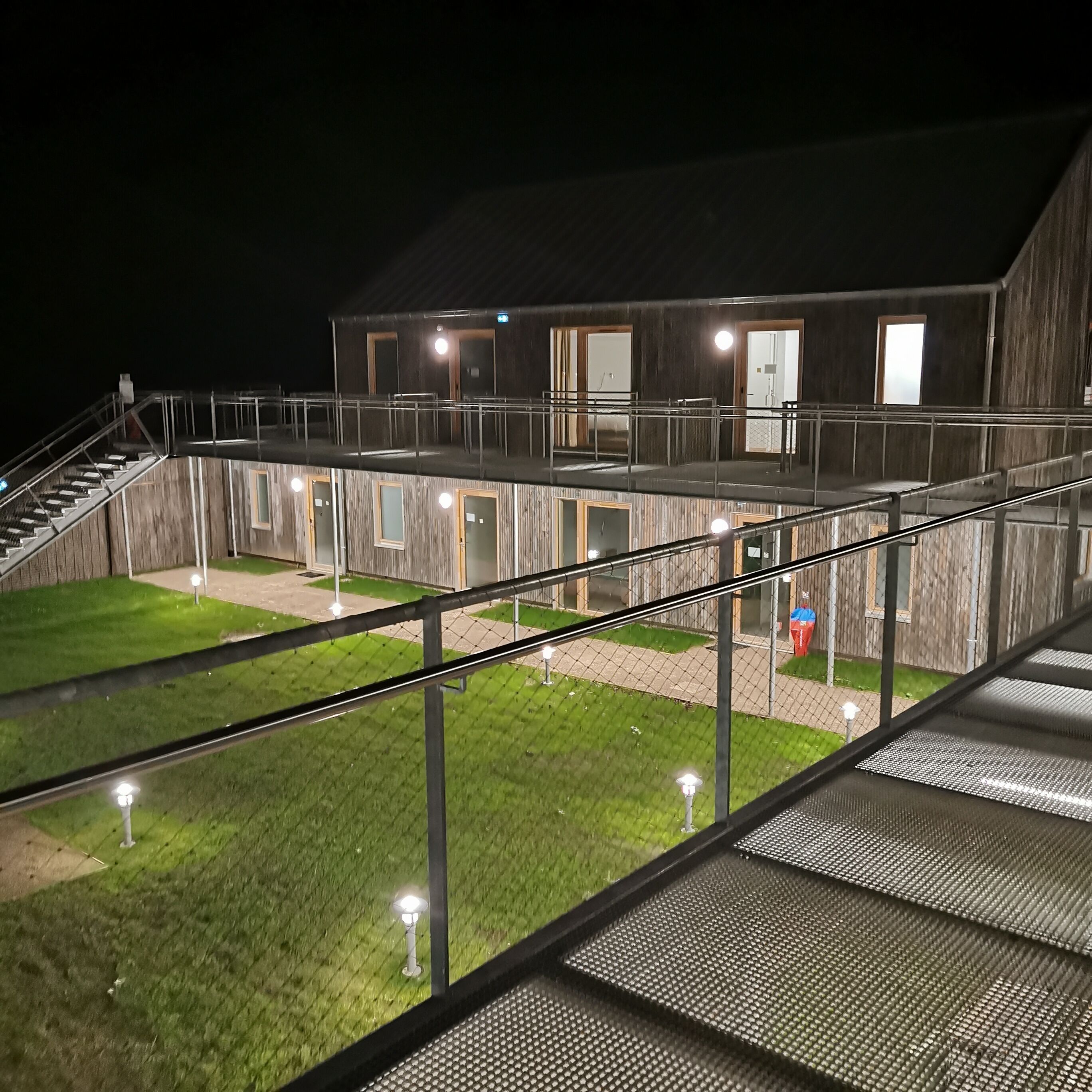A multi-level building with outdoor staircases and a grassy courtyard.
