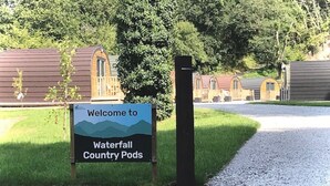 A sign welcoming visitors to Waterfall Country Pods, indicating a campground setting with multiple pod-style accommodations. - Forest Pod 4 (Pet Friendly) -  a glamping pod that sleeps 2 guests  in 1 bedroom (Neath)