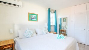 A bedroom with a bed, bedside tables, a mirror, and a door. - 3 Sea Star by BSL Rentals (Worthing)