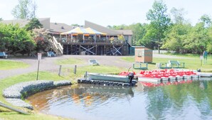 A boat docked at a small pond with a building in the background.