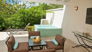 An outdoor patio with a pool, seating area, and a glass table. - Palisades 6a 3 Bedroom Townhouse (Oistins)