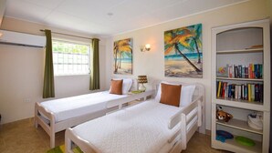 A room with two single beds, a bookshelf, and a window with curtains. - Bella Figura by BSL Rentals (Rockley)