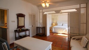 A room with a bed, a desk, a chair, and a mirror. - Church Point Cottage 3 Bedroom Home by Bluescape (Holetown)