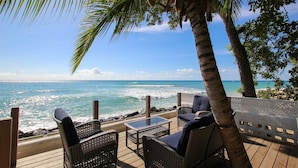 A deck with wicker furniture overlooking the ocean. - Church Point Cottage 3 Bedroom Home by Bluescape (Holetown)