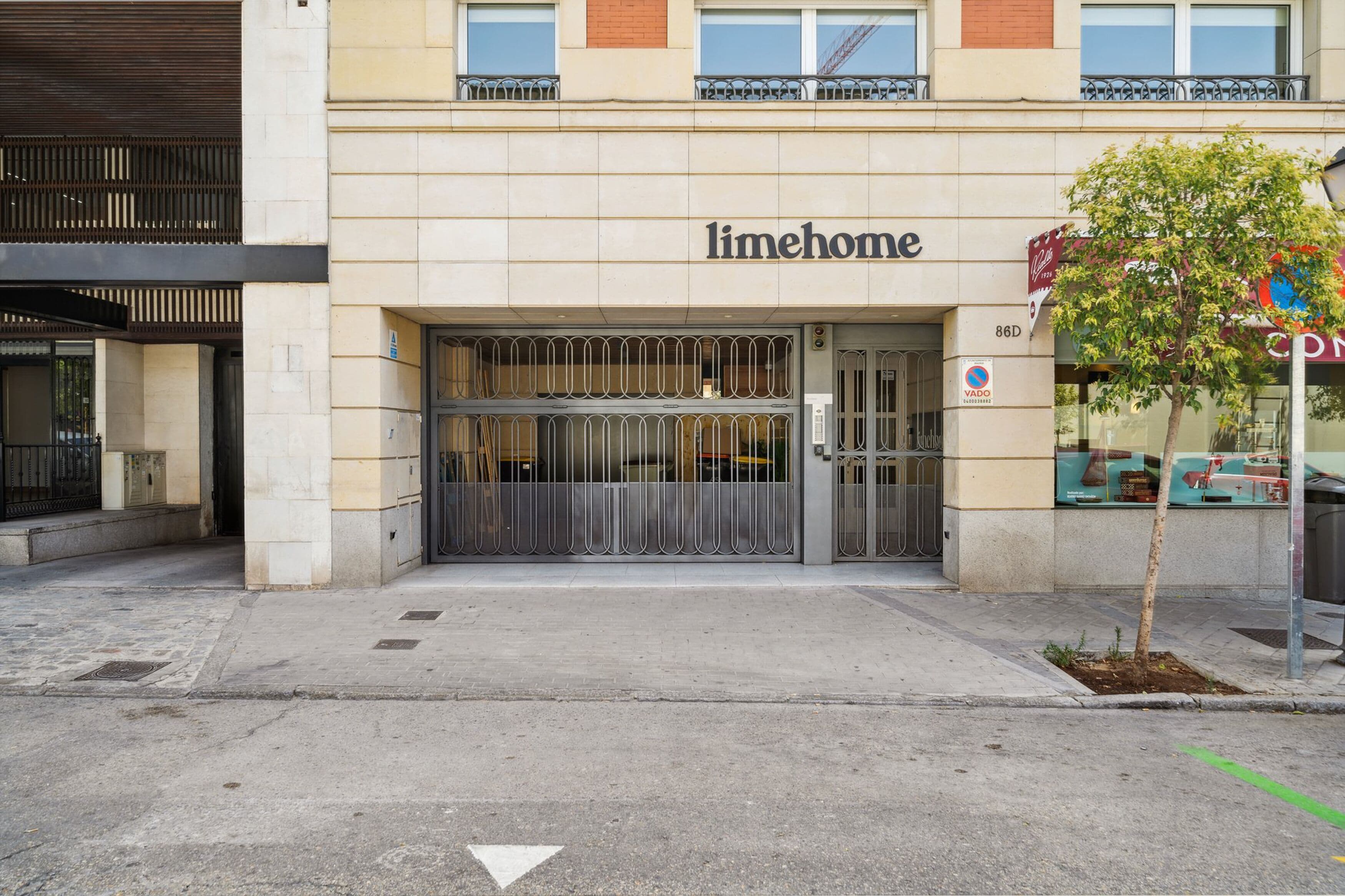 Un edificio con un letrero que dice "limehome" y una entrada con portón.