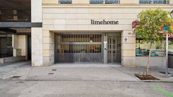 Un edificio con un letrero que dice "limehome" y una entrada con portón.