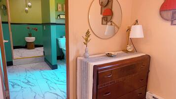 A bathroom with a mirror, a sink, a toilet, and a vanity with drawers.