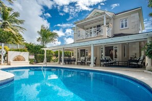 A poolside area with a pool, lounge chairs, and a covered patio. - Royal Westmoreland - Lime Tree House 3 Bedroom Villa (Westmoreland)