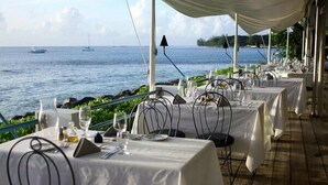 A seaside restaurant with tables set for dining, overlooking the ocean. - Bliss 2 Bedroom Home by Bluescape (Holetown)