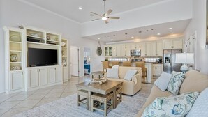 A spacious living area with a television, sofa, and dining table. - Pair-a-dice 3 Bedroom Home by RedAwning (Port Bolivar)