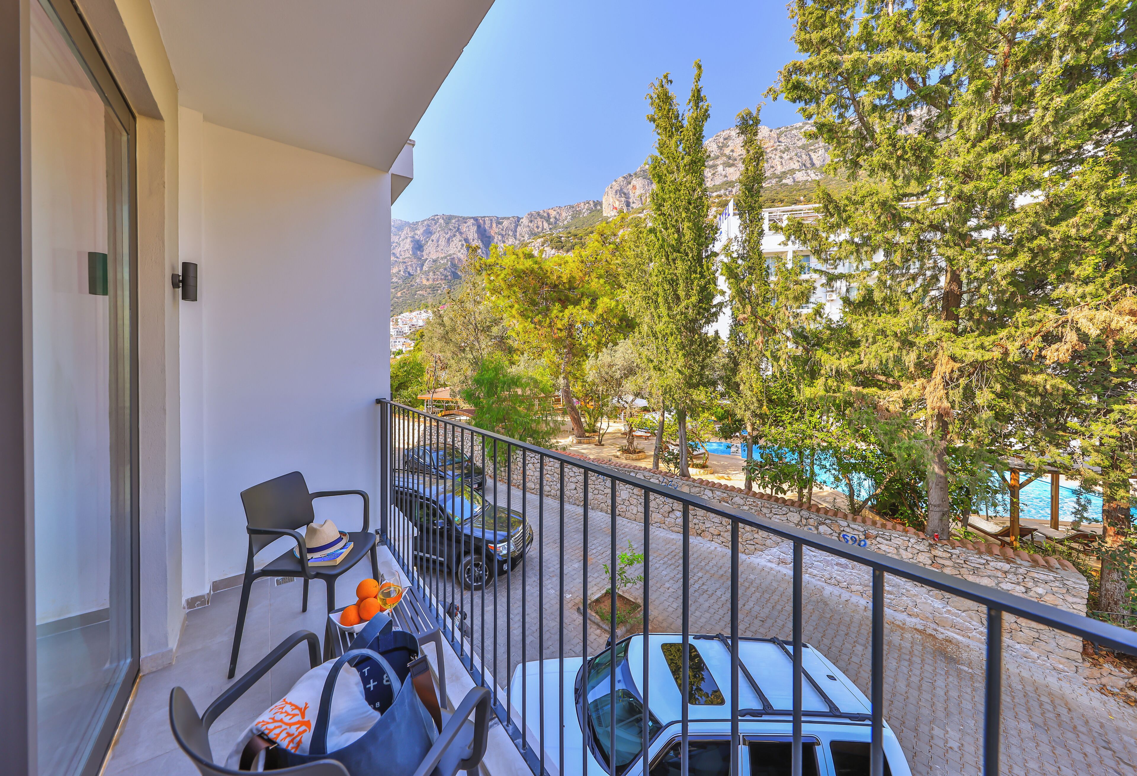 Ein Balkon mit Blick auf Berge, Bäume und einen Pool.