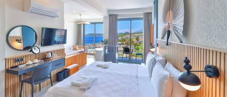 Habitación de hotel con cama, escritorio, televisión y balcón con vistas.