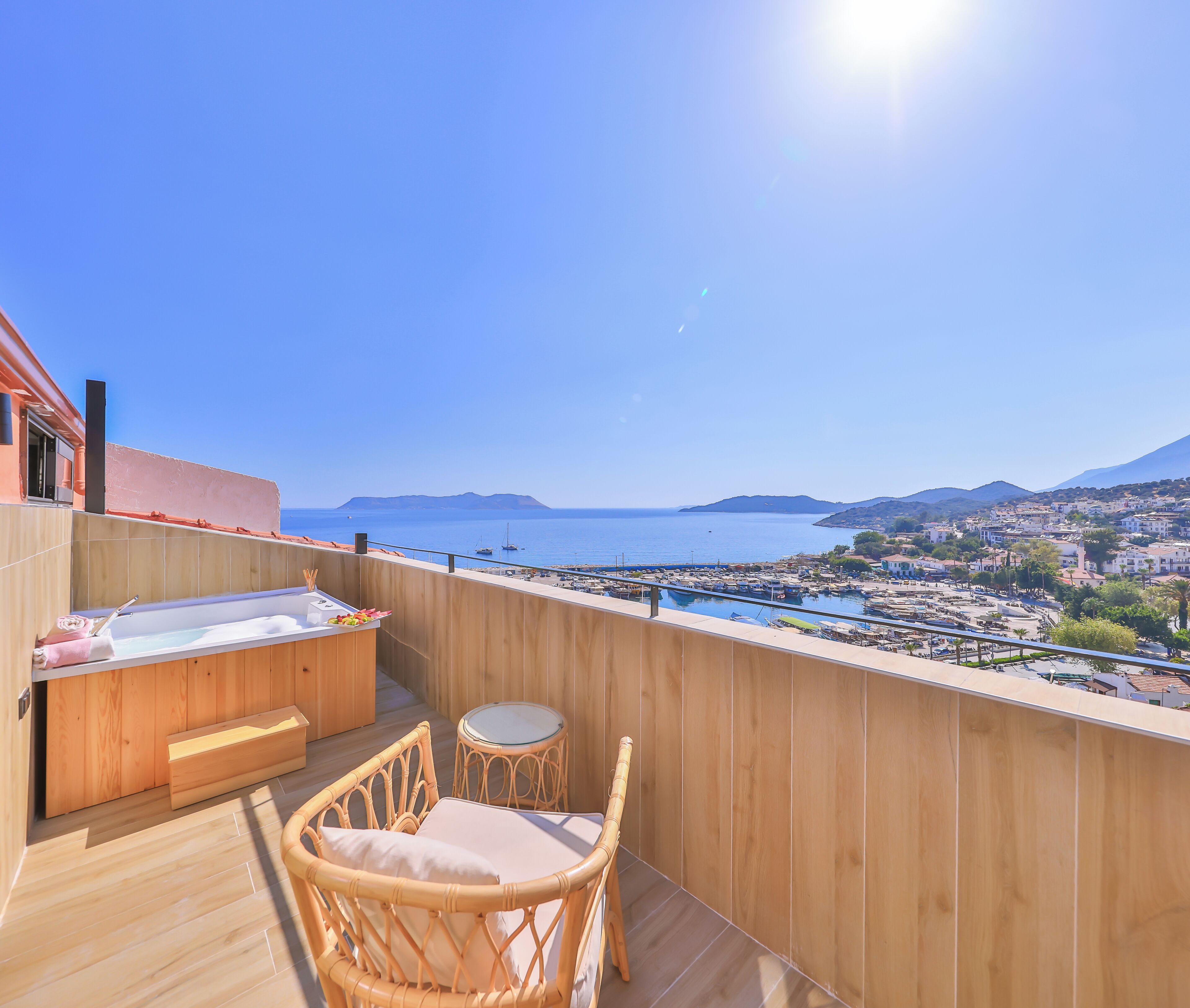 A wooden deck with a hot tub, a small round table, and wicker chairs.
