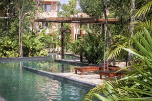 Ein Poolbereich mit Holzliegen und einer Pergola.