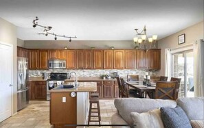 Enjoy cooking and dining in this well-equipped kitchen with a central island, dining area, and comfortable living space.