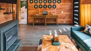 A wooden interior with a fireplace, a coffee table, and a sofa.