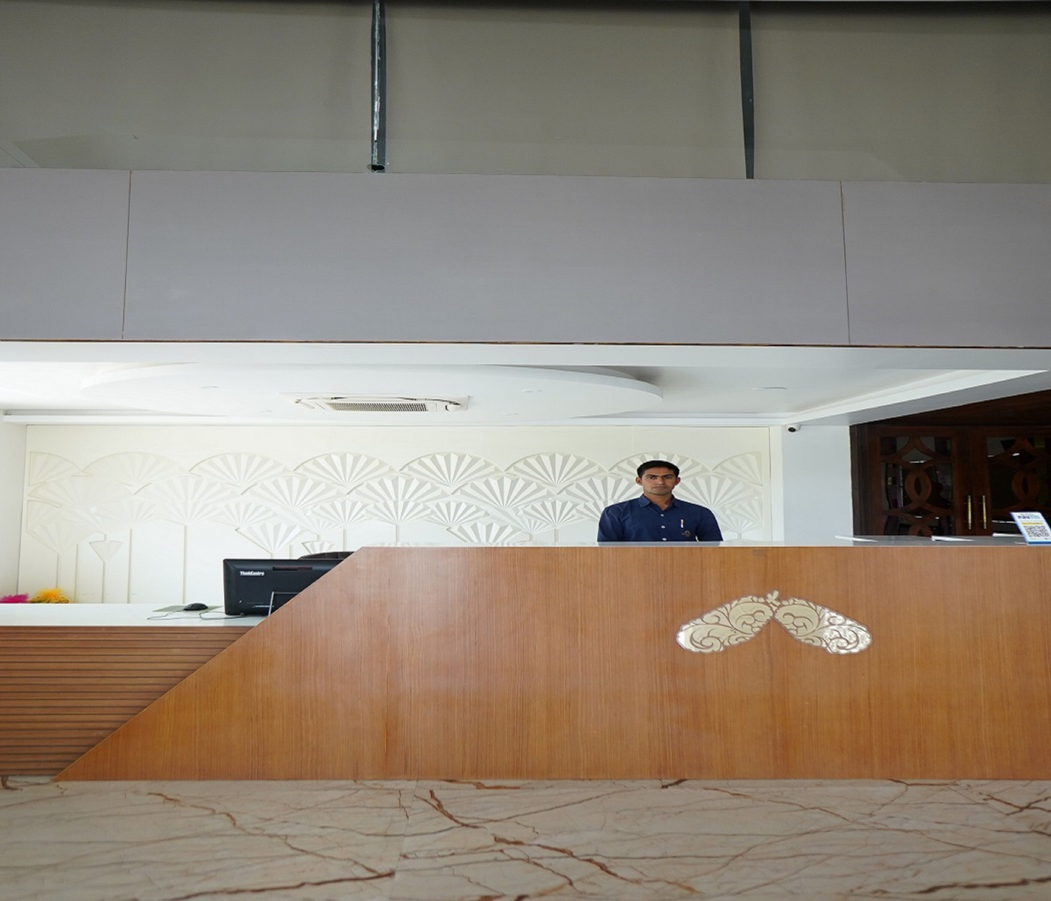 A reception desk with a wooden finish and a decorative emblem.