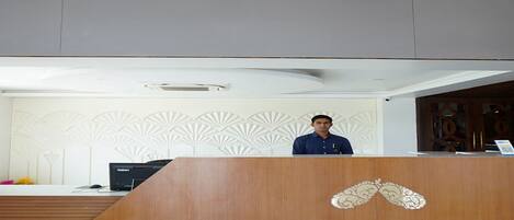 A reception desk with a wooden finish and a decorative emblem.