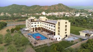 A hotel with a pool, surrounded by greenery and hills. - Bamboo Saa Mulberry Resort Pushkar (Pushkar)