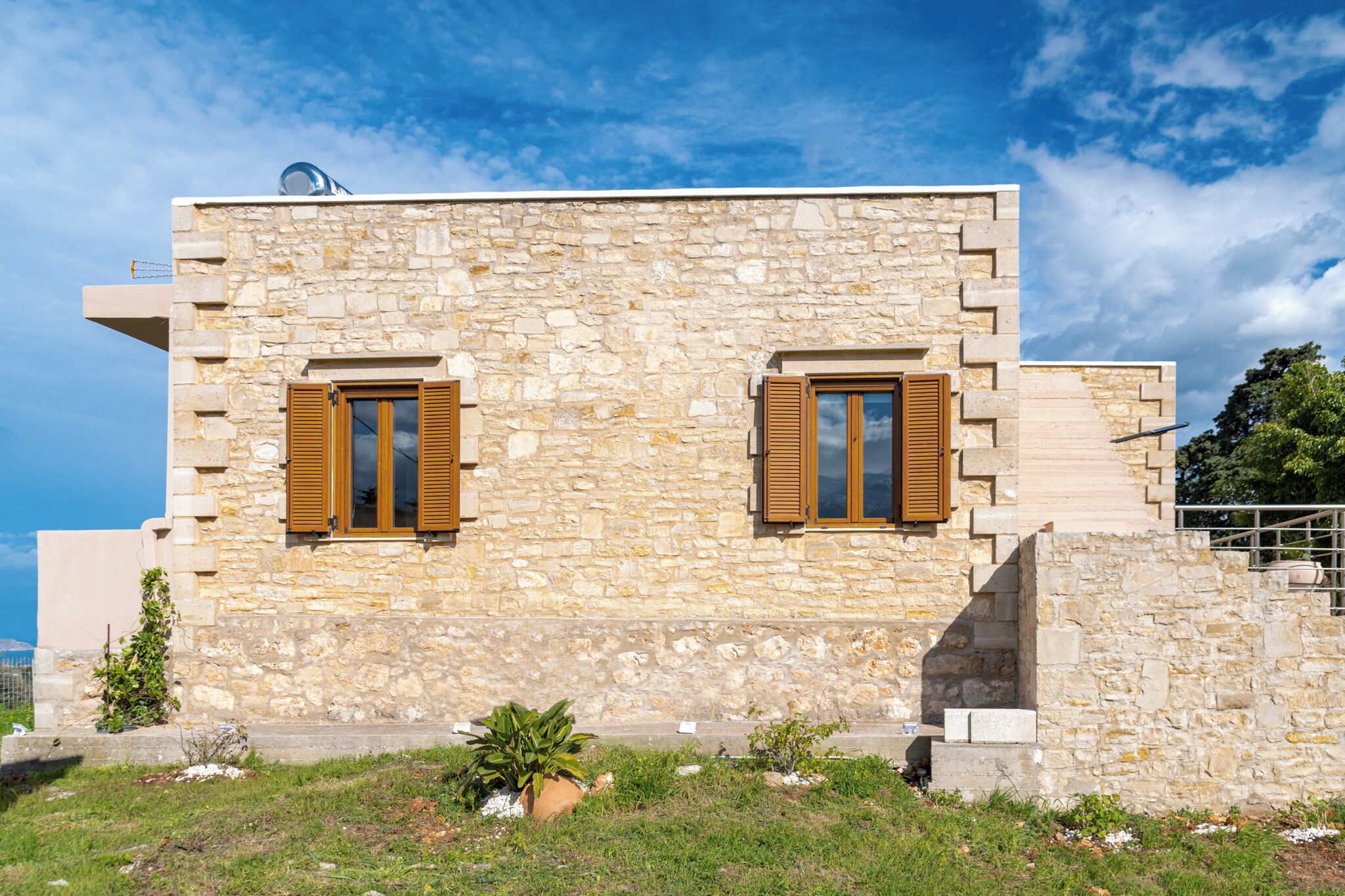 Un bâtiment en pierre doté de deux fenêtres et d’un petit balcon.