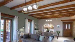 Una sala de estar acogedora con sofá, mesa de comedor y cocina al fondo.