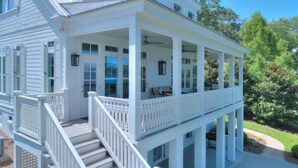 A white two-story house with a covered porch and a staircase leading to the entrance. - Stunning views of Lake Blackshear! (Warwick)