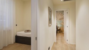 A modern bedroom with a bed, a nightstand, and a wall-mounted lamp. - Riviera Flavour Apartments by Wonderful Italy - Olivo (Santa Margherita Ligure)