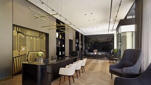 Een modern interieur met een receptiebalie, een zithoek en een bar.