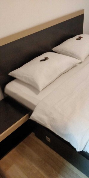 A bed with white bedding and a dark headboard. - Cazare Business-Transit (Balotesti)