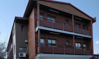 Un edificio de madera de varios pisos con balcones y ventanas.