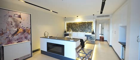 A modern kitchen with a central island, a dining area with a white sofa, and a kitchen island with a built-in oven.
